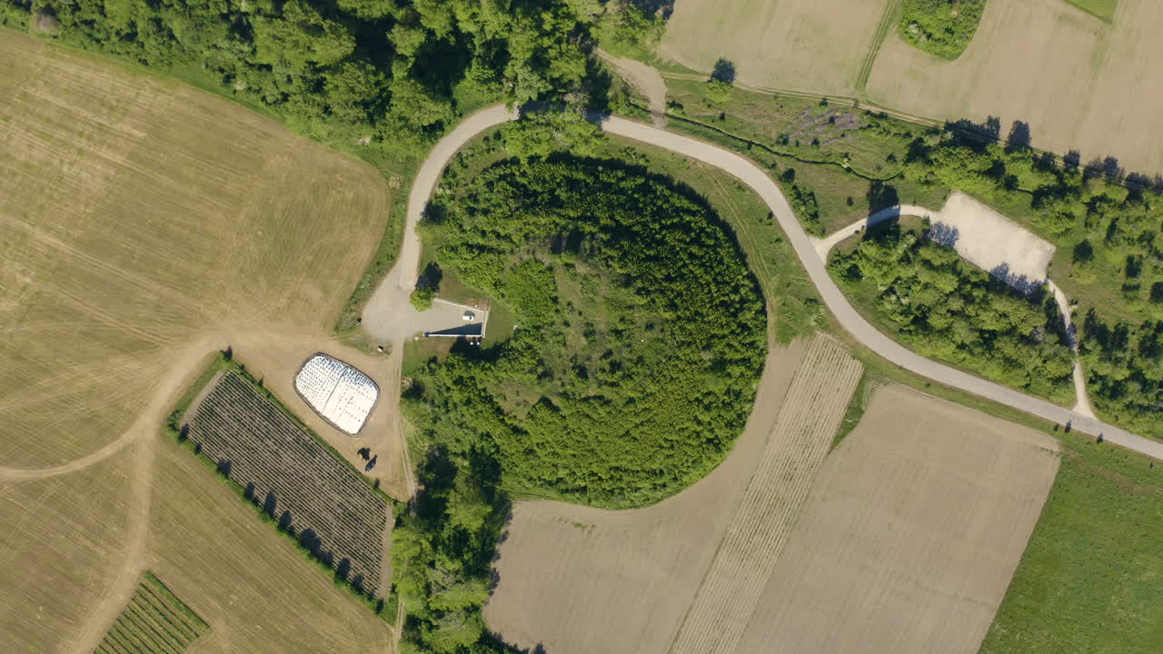 Overhead drone shot of the tomb of Golyama Kosmatka in the valley of the Thracian kings in the middle of an agricultural field in Bulgaria.