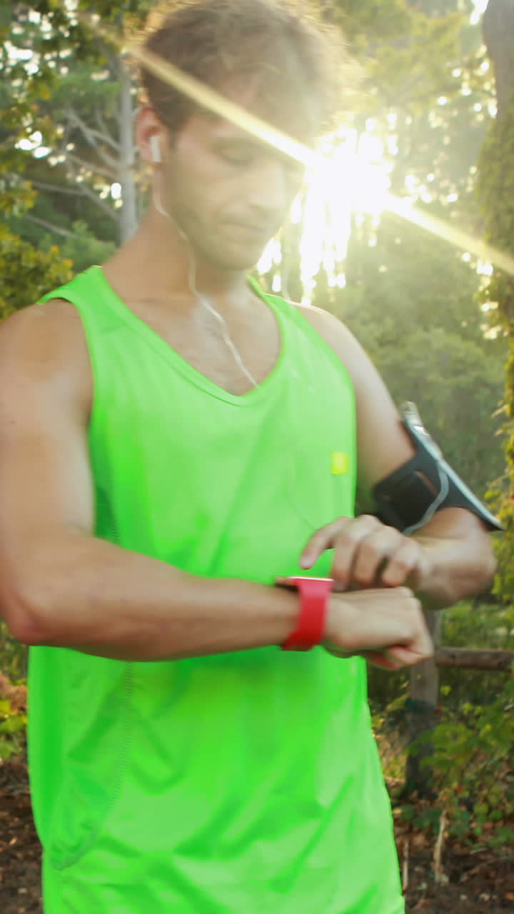 Man checking his smartwatch while jogging in park