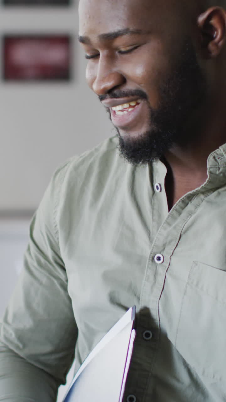 Video of happy african american male teacher in classroom