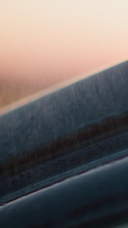 coche bajo tormenta de lluvia al atardecer primer plano. superficie del vehículo con gotas de agua clara en tormenta de agua en el campo de la noche. conducir auto en la lluvia