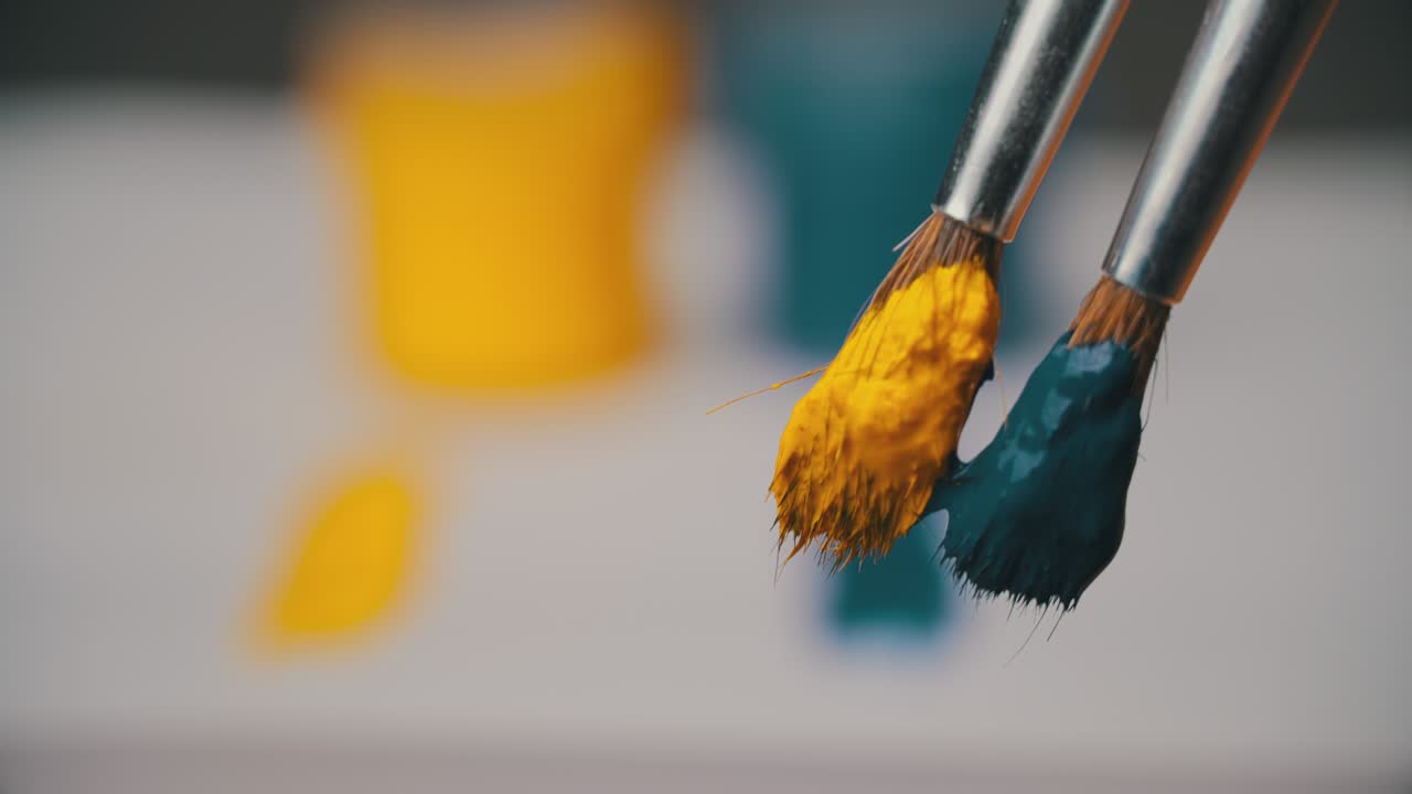 toman pintura amarilla y azul con un pincel, ucrania