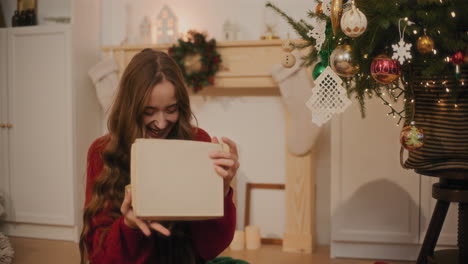 Mujer-Riendo-Mientras-Abre-El-Regalo-De-Navidad