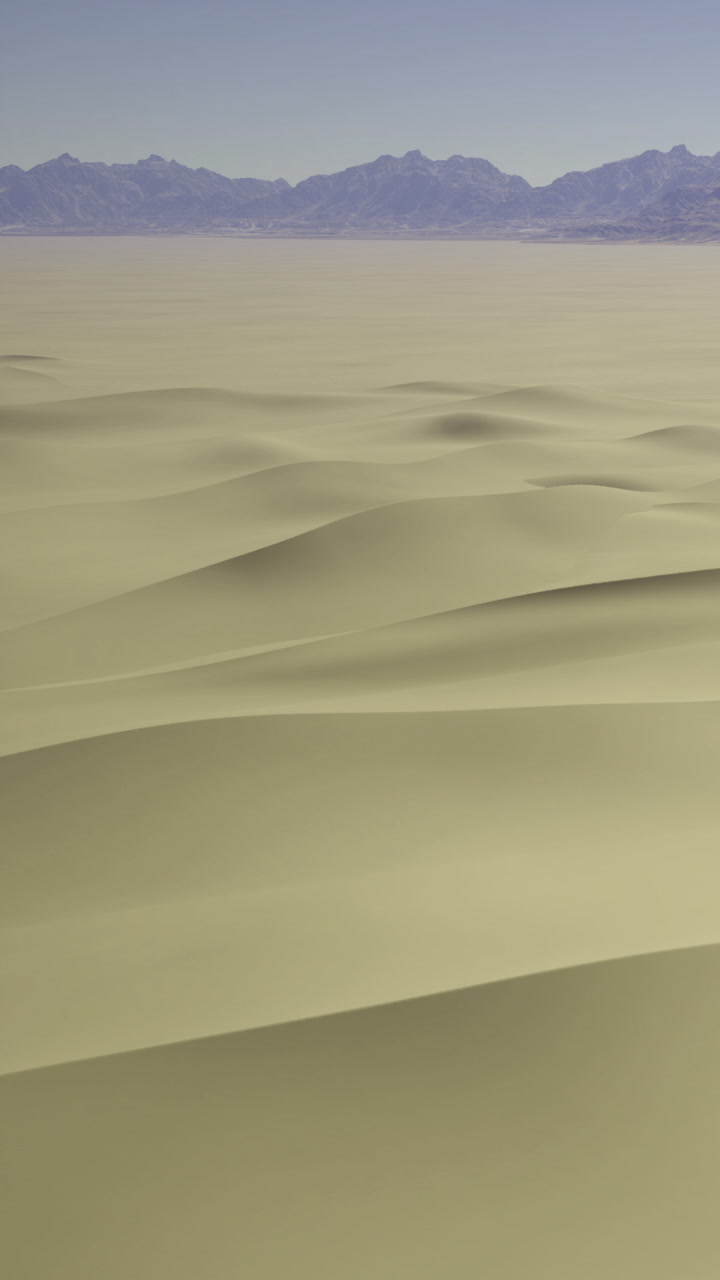 Waves of golden sand stretch endlessly under a soft blue sky at dusk
