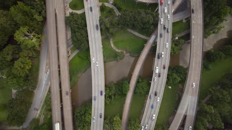 Descending-shot-of-cars-on-freeway-over-the-Buffalo-Bayou-near-downtown-Houston,-Texas