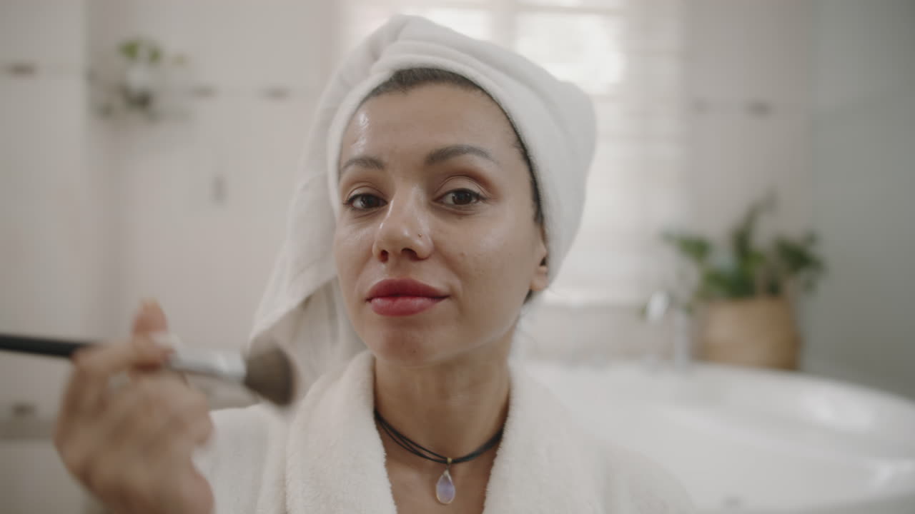POV di una donna che fa il contouring del viso con un pennello