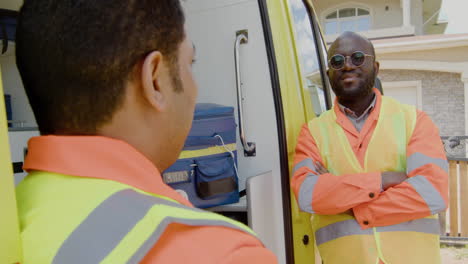 two medical assistants talking in front of an ambulance 1