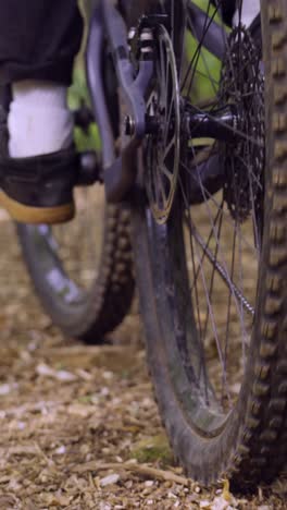 vertical video of man on mountain bike with close up of rear tyre brake and gears