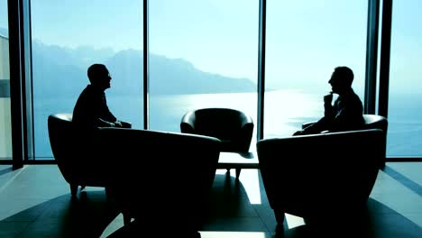 two business people meeting in high rise lobby hall talking about future finance agreement deal