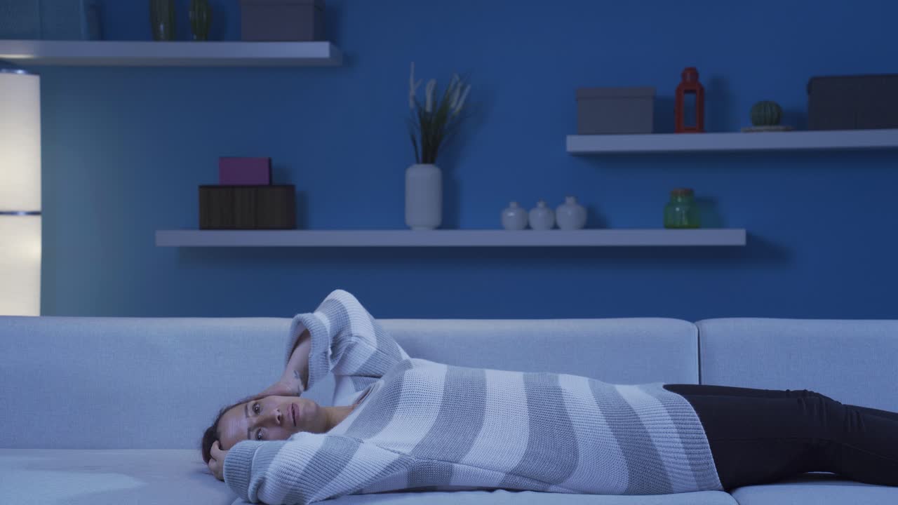 소파에 누워 있는 우울한 여자.