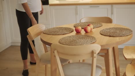 a beautiful pregnant woman tidying her home, engaged in household chores. the scene captures domestic life, maternity, and the balance of routine and preparation during pregnancy