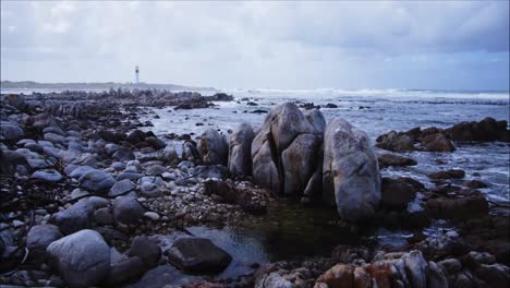 Felsformationen-An-Der-Hangklip-Bay-Mit-Leuchtturm-Im-Hintergrund