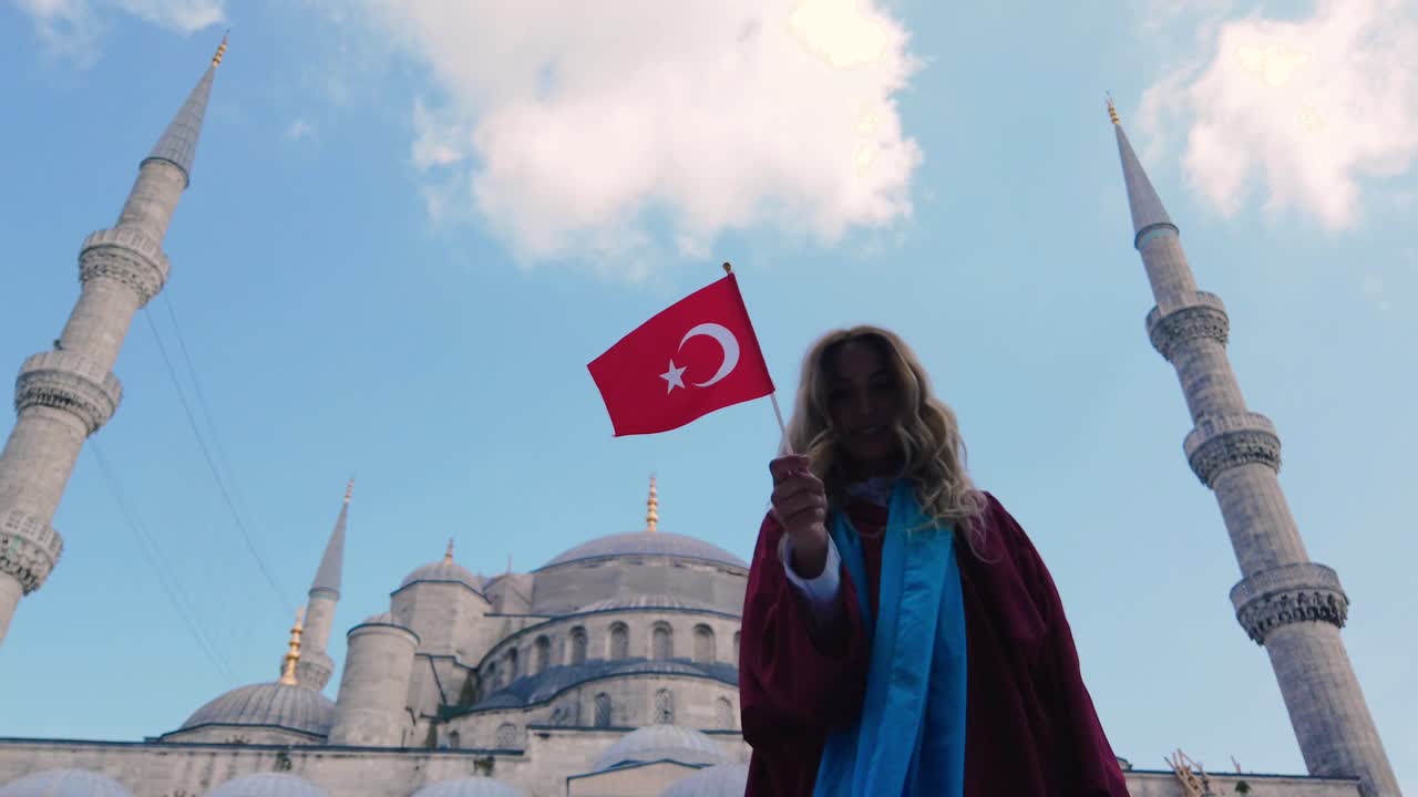 câmera lenta: garota bonita e atraente em camisa acena bandeira turca com vista da mesquita do sultão ahmet em istambul, turquia