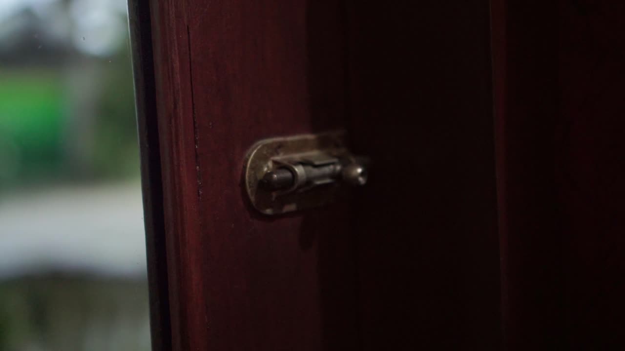 Mano che aziona una serratura manuale. Concetto di ingresso, sistema di sicurezza e spazio personale in un ambiente residenziale