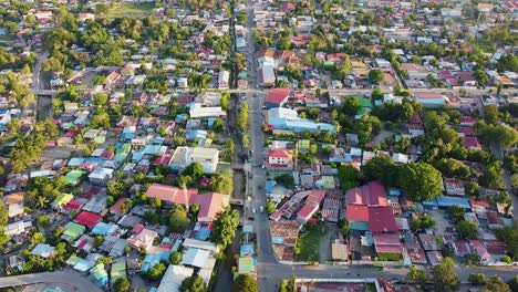 stunning view of inner city landscape of capital dili, timor-leste in southeast asia with tree lined streets, traffic commuting, and colorful red and blue tinned roof buildings