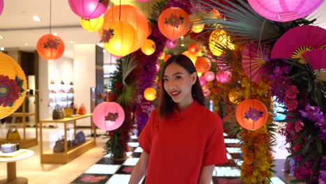 cute asian woman is happy as she walks through a home furnishings department store looking at chinese lamps - slow motion