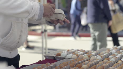 people buying and selling eggs at a bustling farmers market