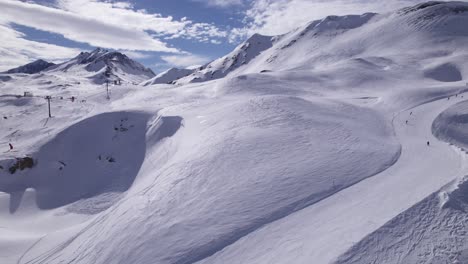 Drone-Footage-of-Downhill-Skiers-in-a-Beautiful-Mountain-Scene,-France---Dolly-In-Shot---Shot-in-Tignes-and-Val-d'Isere