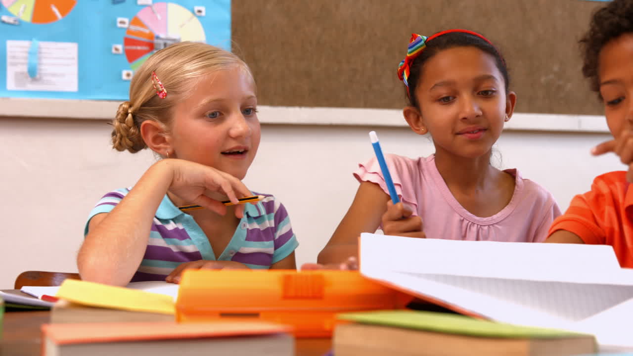 Niedliche Schüler unterhalten sich im Unterricht