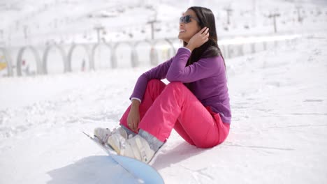 Gorgeous-young-woman-using-a-snowboard