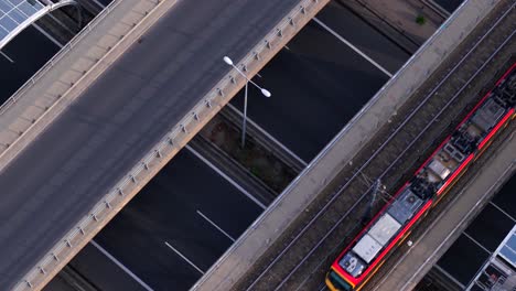 warsaw city traffic and public transportation, poland. static top down aerial view of tram moving on bridge above highway