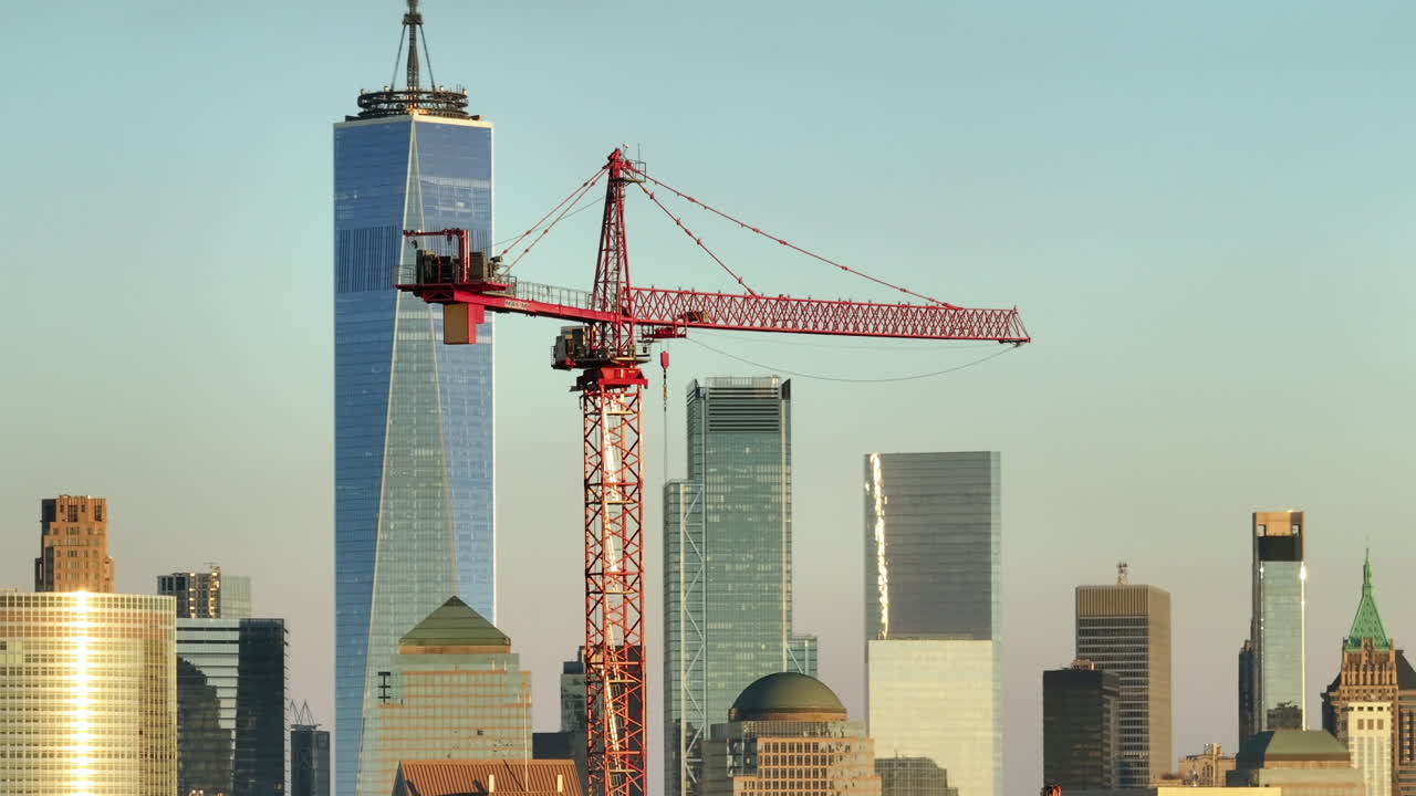 Aerial view of a construction crane on a clear day. Shot in Hoboken, New Jersey with the world trade center in the background.