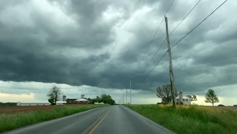 dark storm clouds over a small farming town rural road