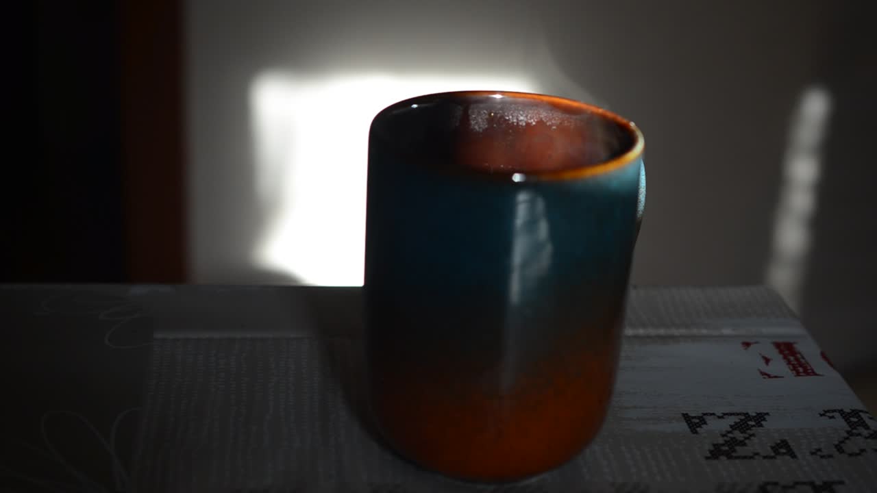 Cup of coffee on a table. Coffee and sun
