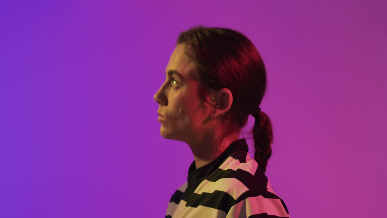 백인 여성 럭비 선수 의 초상화 는 네온 분홍색 조명 위 에 있다