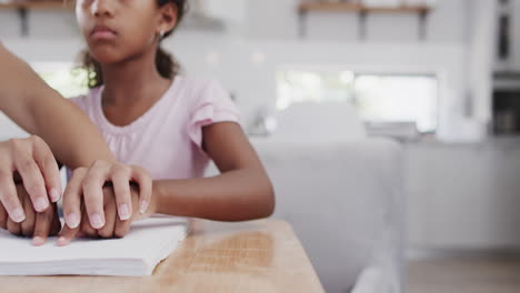 african american mother and daughter reading braille, with copy space, slow motion