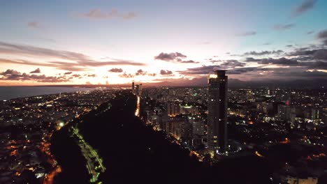 aerial of skyscrapers district and mirador sur urban park in santo domingo city at sunset