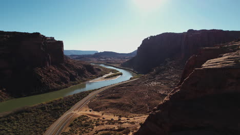 Luftaufnahme-Der-Straße-Und-Des-Colorado-River-Unter-Malerischen-Klippen-Aus-Rotem-Sandstein-In-Der-Nähe-Von-Moab,-Utah,-USA