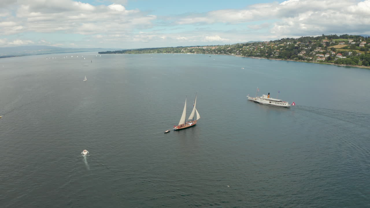 tomada aérea en círculo alrededor de un velero para revelar la ciudad de ginebra