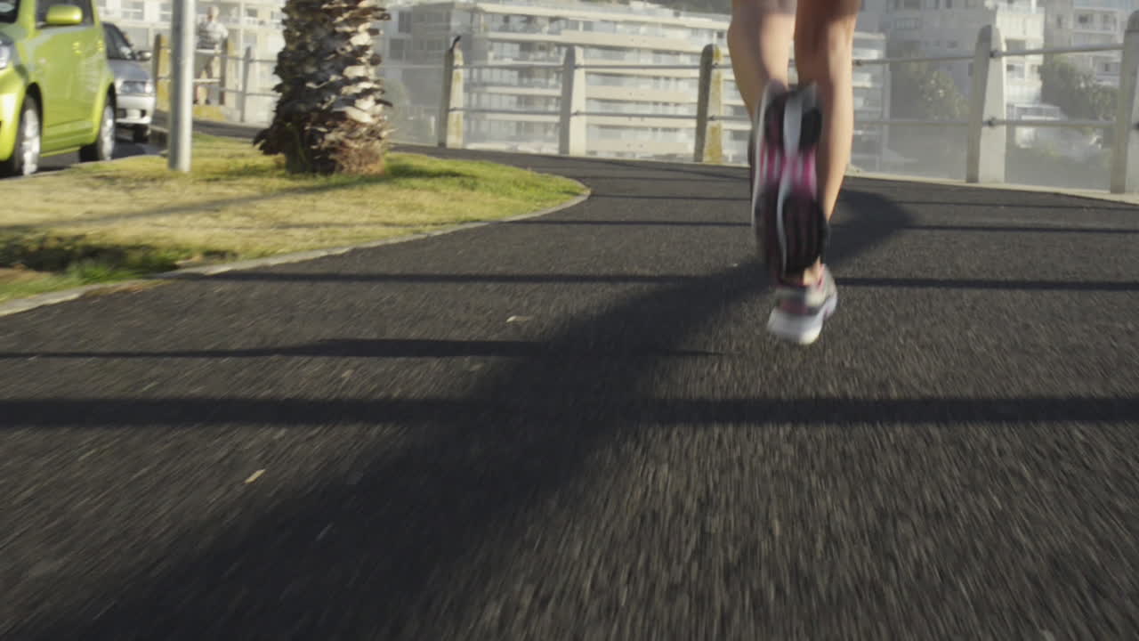 Mixed race woman runner running on road