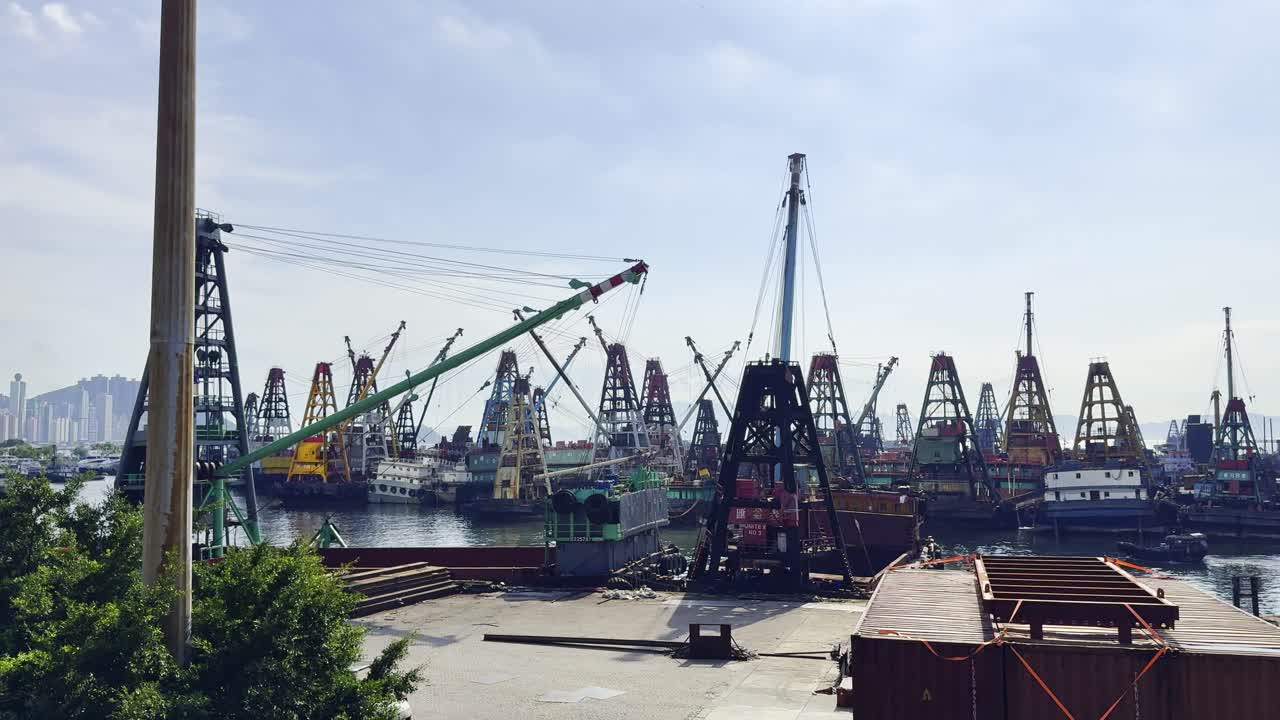 A bustling Hong Kong shipyard featuring multiple cranes, docked vessels, and active harbor operations, highlighting industrial maritime activity, logistics, and the vibrant energy of the port