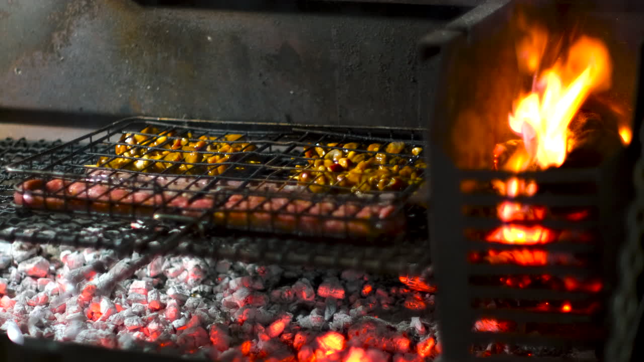 Spiedini di maiale e salsiccia tradizionale sudafricana vengono grigliati su carboni ardenti