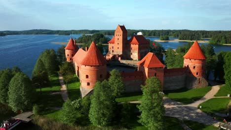 trakai island castle surrounded with green lush trees on sunny day in trakai, lithuania