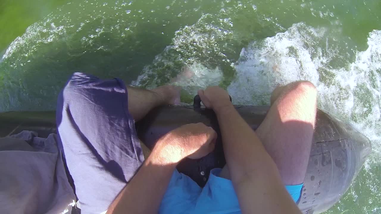 Chilling on the boat with the legs in the water while man is driving his boat