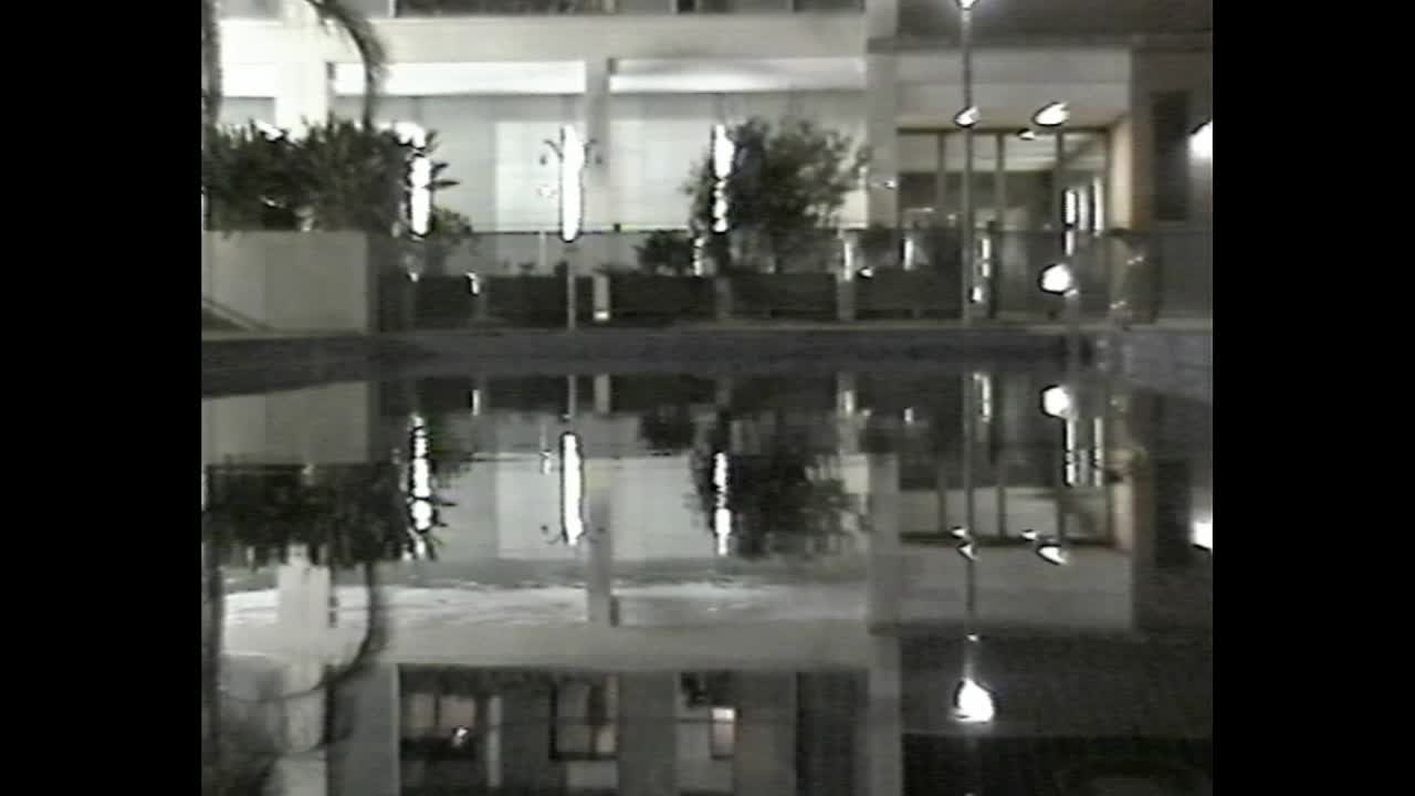 Reflections in pool at night in urban courtyard