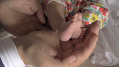 dad holding baby feet in hands