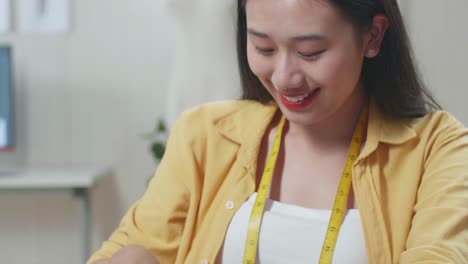아시아 여성 디자이너가 미래의 드레스의 템플릿을 만니다. 그녀는 세부 사항의 도자기 윤을 그립니다.