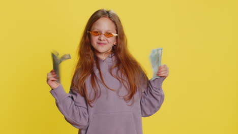 child girl kid holds fan of cash money dollar banknotes celebrate dance success game winner wealth