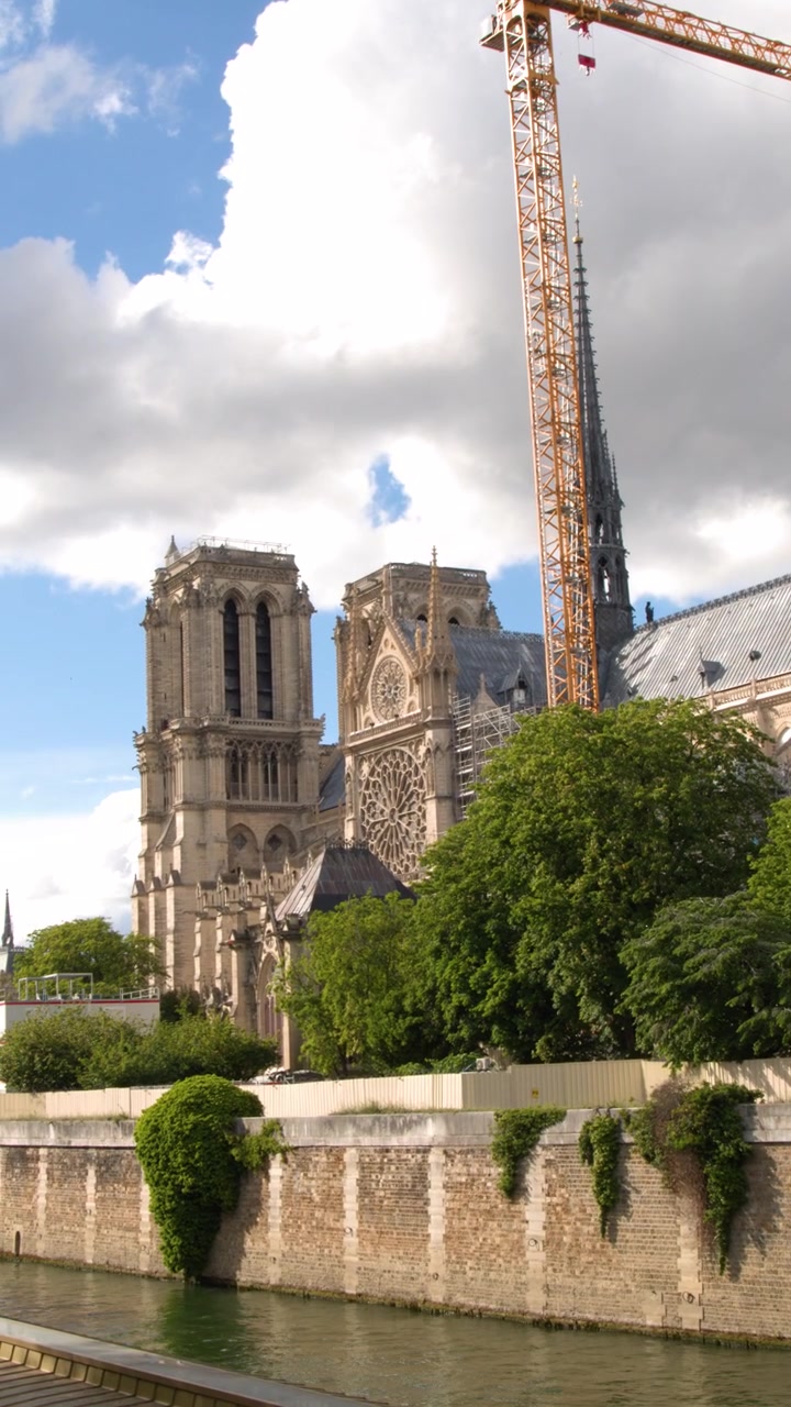 Panoramica della Cattedrale di Notre Dame in ristrutturazione con gru, lungo il fiume Senna, Parigi.
