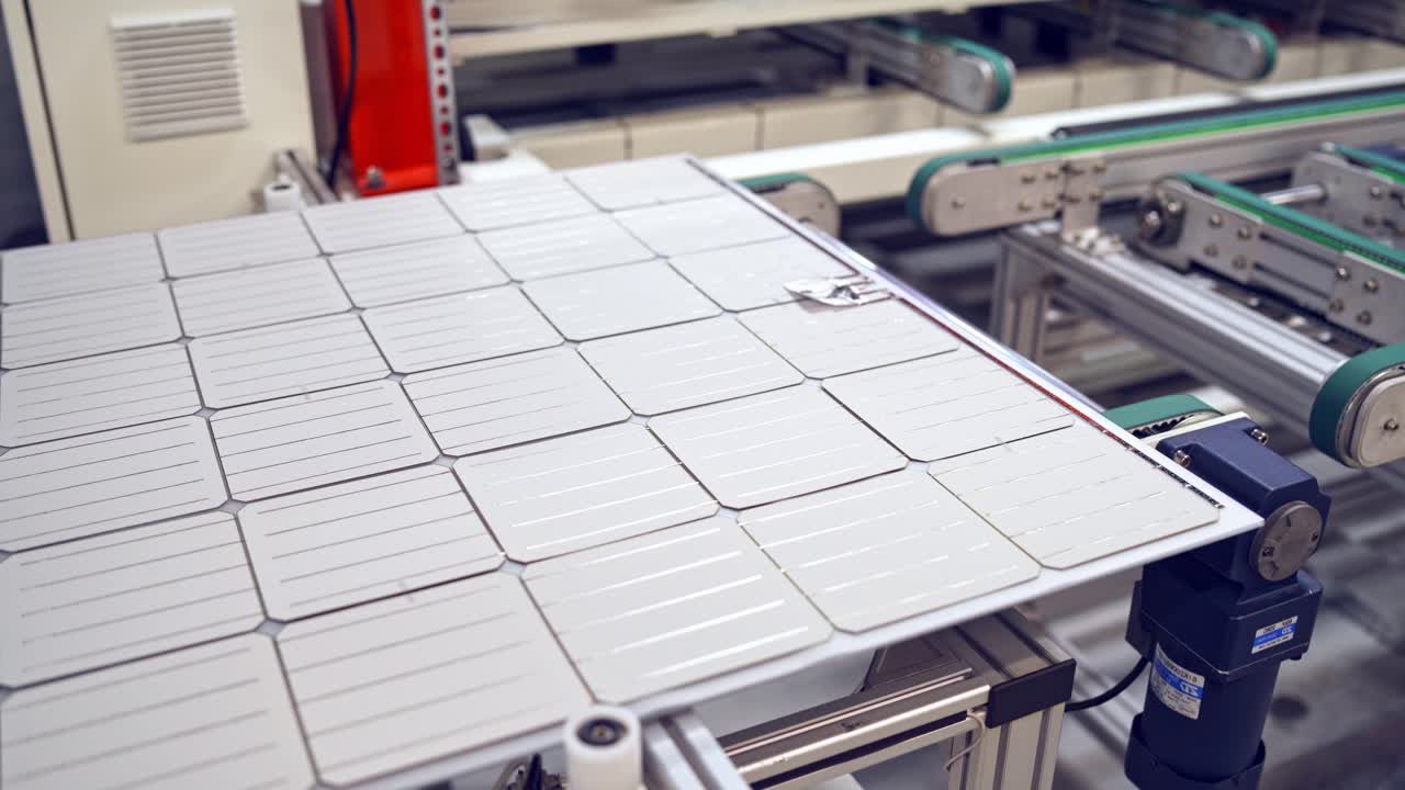 Solar panel moves on a conveyor belt in the robotic factory. Modern plant of producing ecological solar cells. Automated factory indoors.