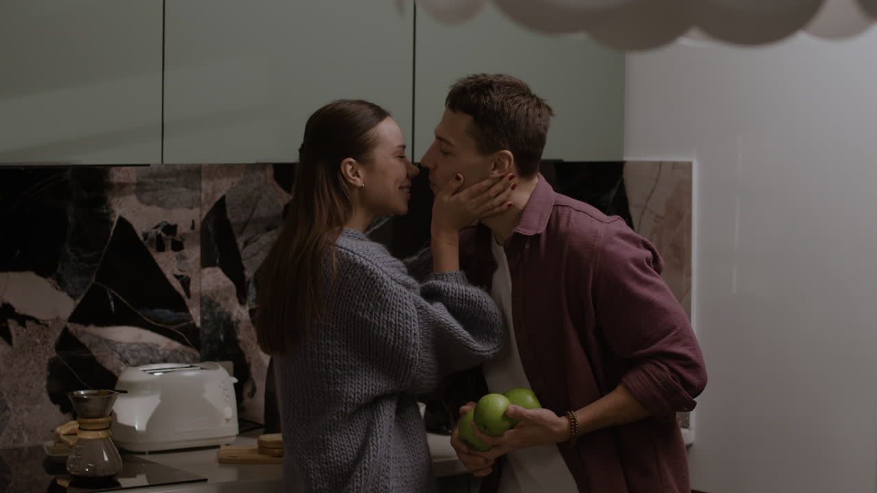 Couple Playing with Apples in the Kitchen