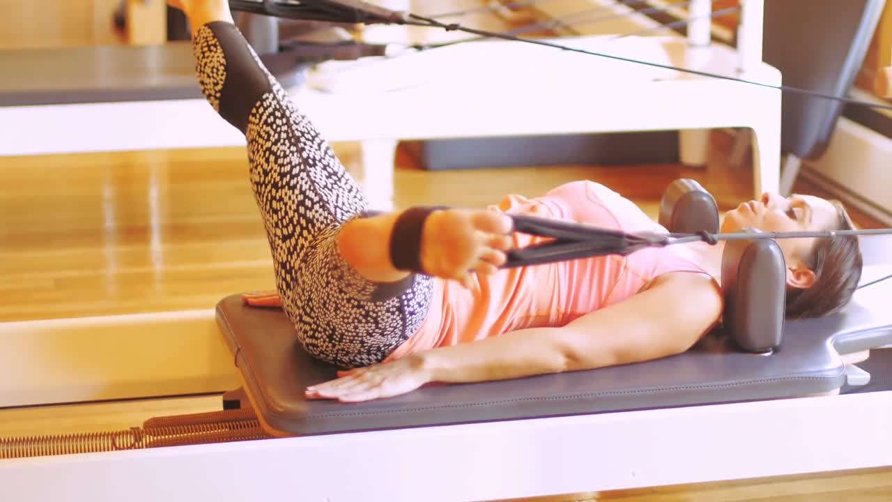 체육관 장비 를 사용 하여 운동 하는 여자