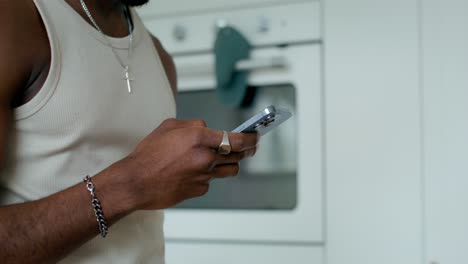 man using smartphone in kitchen