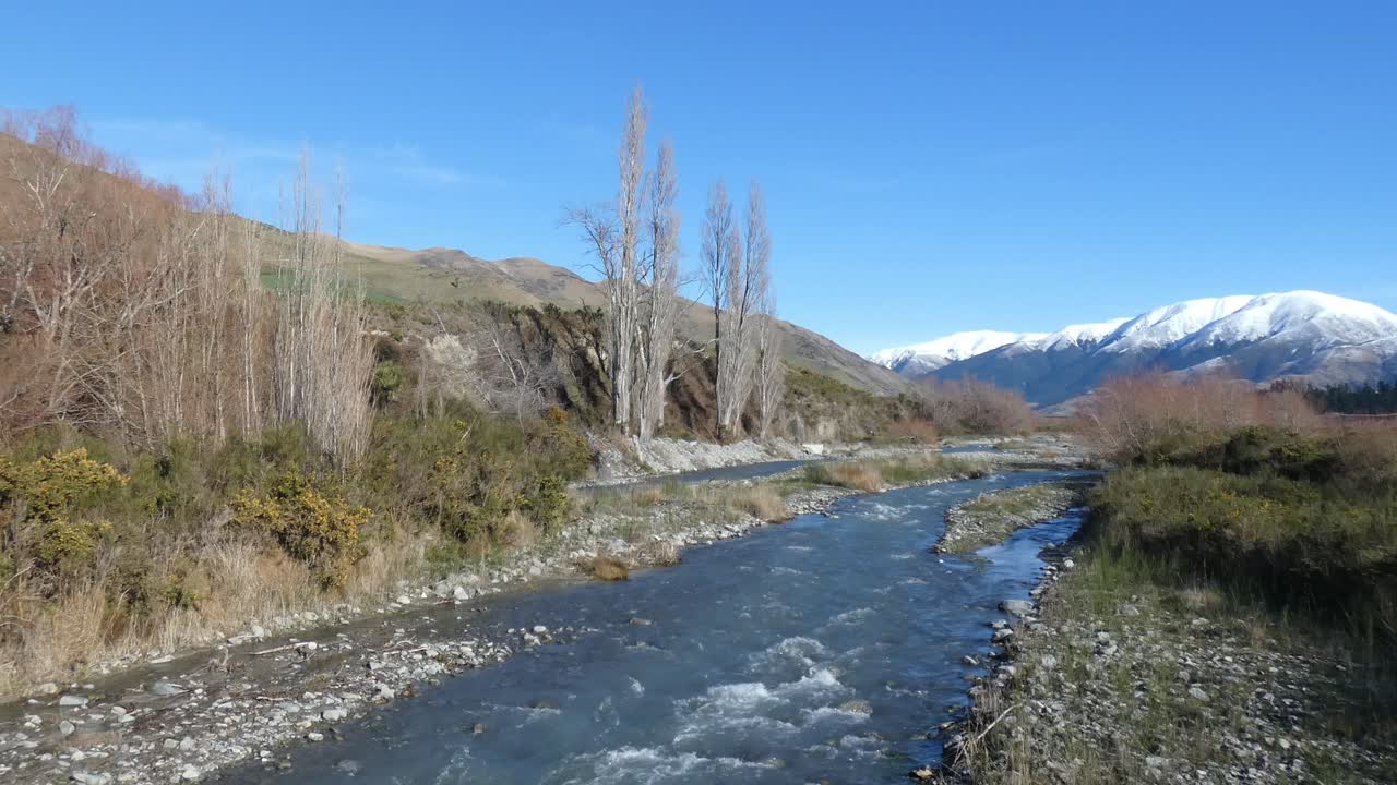 Fiume di alta campagna scorre placidamente in una chiara e calma giornata di metà inverno – Fiume Kowai, Canterbury.