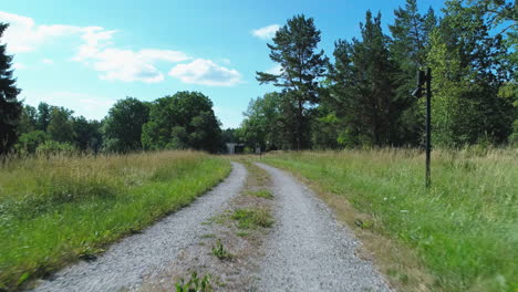 Aerial-shot-along-a-gravel-path-on-the-Swedish-countryside