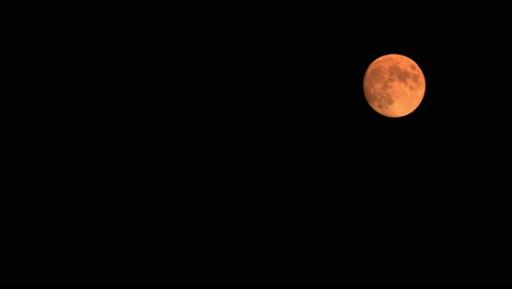 Lapso-De-Tiempo-De-La-Luna-Llena-De-Sangre-Que-Se-Eleva-En-El-Cielo,-Naranja-Brillante-Iluminada