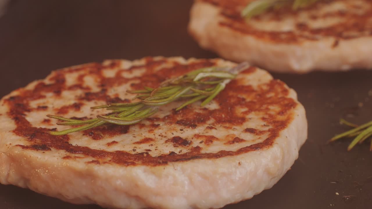 Cooking American fat smash burger on grill close-up. Chiken or fish cutlet smashing by burger press. The chef in kitchen of the restaurant making cutlets for burgers - smash burger beefsteak. Fast and street food concept. High quality 4k footage